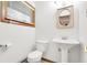 This bathroom features a toilet, sink, mirror, and window, all in a clean and tidy space at 4935 W Carriage Dr, New Palestine, IN 46163