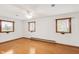 Spacious bedroom with hardwood floors and three windows providing natural light at 4935 W Carriage Dr, New Palestine, IN 46163