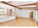 Open-concept living room featuring hardwood floors, wood beams, and natural light at 4935 W Carriage Dr, New Palestine, IN 46163