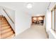 Bright living room featuring a brick fireplace, stairs to the upper level, and a large window for natural light at 4935 W Carriage Dr, New Palestine, IN 46163
