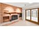This cozy sunroom features a brick fireplace, access to an outdoor space, and large windows for natural light at 4935 W Carriage Dr, New Palestine, IN 46163