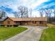 Charming brick home featuring a ramp, attached garage, and well-manicured lawn at 619 Heritage Ln, Anderson, IN 46013