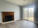 Spacious living room featuring laminate flooring, a fireplace, and a sliding glass door at 6640 Manassas Dr, Indianapolis, IN 46241