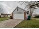 View of a two-car garage with white door, part of the brick and gray exterior of the home at 7352 Crickwood Pl, Indianapolis, IN 46268