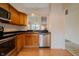 Well-lit kitchen featuring stainless steel appliances, wood cabinetry, and a view of the dining room at 7352 Crickwood Pl, Indianapolis, IN 46268