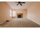 Spacious carpeted living room with a cozy fireplace and ample natural light from a nearby window at 7352 Crickwood Pl, Indianapolis, IN 46268