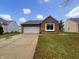 Charming brick home with a two-car garage and well-maintained lawn on a sunny day at 7850 Park North Bnd, Indianapolis, IN 46260