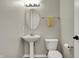 Charming half bath featuring a pedestal sink, toilet, and neutral decor at 8613 N Meridian St, Indianapolis, IN 46260
