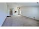 Bright living room featuring neutral carpeting, ceiling fan, and open view to the kitchen at 934 Sorrell Ct, Lebanon, IN 46052