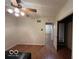 An airy bedroom featuring a ceiling fan, wood-look flooring, and hallway access at 1054 Carters Grove, Indianapolis, IN 46260