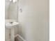 A half bathroom showcasing a pedestal sink, mirror, and modern fixtures, complemented by sleek gray flooring at 10719 Crackling Dr, Indianapolis, IN 46259