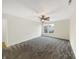 A spacious bedroom with a ceiling fan and plush carpeting provides comfort and style, complemented by ample natural light at 10719 Crackling Dr, Indianapolis, IN 46259