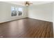 A bright bedroom is illuminated by a ceiling fan and natural light from a window, highlighting the wood flooring at 10719 Crackling Dr, Indianapolis, IN 46259