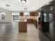 A well-lit kitchen features wood cabinets, an island, stainless steel appliances, and sliding door access to the backyard at 10719 Crackling Dr, Indianapolis, IN 46259