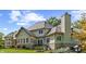 Exterior view of a luxury home showcasing stone and stucco facade, windows, and well-manicured lawn at 10821 Club Point Dr, Fishers, IN 46037