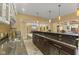 Basement bar area with dark cabinetry, dark countertops, pendant lighting, and stone tile flooring at 10821 Club Point Dr, Fishers, IN 46037