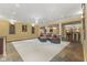 Open basement area featuring a gray sectional sofa, bar area, a decorative chandelier, and stone tile flooring at 10821 Club Point Dr, Fishers, IN 46037