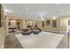 Open basement area featuring a gray sectional sofa, pool table, a decorative chandelier, and stone tile flooring at 10821 Club Point Dr, Fishers, IN 46037