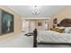 Elegant bedroom with a large bed, decorative painting and carpet floors, leading to additional rooms at 10821 Club Point Dr, Fishers, IN 46037