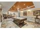 Basement game room with a pool table, fireplace, and stone tile flooring; great for entertaining at 10821 Club Point Dr, Fishers, IN 46037