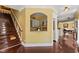 Open-concept hallway with hardwood floors, yellow walls, and stairwell leading up at 10821 Club Point Dr, Fishers, IN 46037