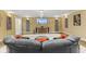 Basement Living Room, featuring a stone accent wall, large TV, and a gray sectional sofa with orange pillows at 10821 Club Point Dr, Fishers, IN 46037