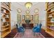 Well-lit home office with built-in bookshelves, a large desk, and comfortable chairs creating an inspiring workspace at 10821 Club Point Dr, Fishers, IN 46037
