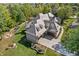 Aerial view of a home, highlighting its three-car garage, surrounding greenery, and elegant architecture at 10821 Club Point Dr, Fishers, IN 46037