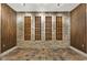 A rustic wine cellar featuring custom shelving, stone walls, and tiled flooring at 10821 Club Point Dr, Fishers, IN 46037