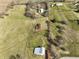 This aerial photograph shows various outbuildings across the verdant property with mature trees at 11686 S 825 W, Edinburgh, IN 46124