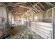 Interior view of horse barn with exposed rafters, divided stalls and a black water trough at 11686 S 825 W, Edinburgh, IN 46124