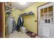 Mudroom with yellow walls, white door, and storage shelves for shoes and coats at 11686 S 825 W, Edinburgh, IN 46124