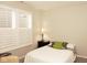 A bedroom with a bed, nightstand with lamp, and a window with white shutters at 1274 Clairet, Westfield, IN 46074