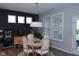A dining room featuring a round table with chairs, modern lighting, and a window with white shutters at 1274 Clairet, Westfield, IN 46074