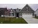 Charming home featuring gray siding, white trim, and a well-manicured front lawn and a two car garage at 1274 Clairet, Westfield, IN 46074