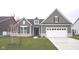 Charming, gray, two-story home with a well-manicured lawn and attached two-car garage at 1274 Clairet, Westfield, IN 46074