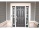 Elegant black front door with sidelights and brick accents, creating a welcoming entrance at 1274 Clairet, Westfield, IN 46074