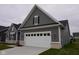 Attached two-car garage with gray siding and white trim, enhancing the curb appeal of the home at 1274 Clairet, Westfield, IN 46074