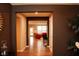 A hallway view into a living room with brown walls and hardwood floors at 1274 Clairet, Westfield, IN 46074