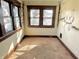 Bedroom with tan carpet, wooden trim and two windows letting in plenty of natural light at 1425 N Lasalle St, Indianapolis, IN 46201