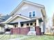 Charming two-story home featuring a covered front porch with brick accents and a well-manicured lawn at 1425 N Lasalle St, Indianapolis, IN 46201