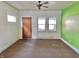 View of an empty living room featuring natural light, a ceiling fan, and hardwood door at 1425 N Lasalle St, Indianapolis, IN 46201