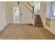 View of an empty living room leading to a staircase, offering a spacious layout and design potential at 1425 N Lasalle St, Indianapolis, IN 46201