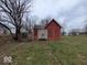 An exterior view of a derelict, boarded-up home, in need of significant repair at 1724 Sheldon St, Indianapolis, IN 46218