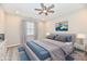 Staged bedroom showcasing a ceiling fan, large bed with soft linens, neutral walls, and stylish decor at 1803 Jackson St, Fortville, IN 46040