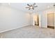 Spacious bedroom with carpeted floor, ceiling fan, and open doorways to ensuite bathroom and walk-in closet at 1803 Jackson St, Fortville, IN 46040