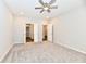 Spacious bedroom with carpeted floor, ceiling fan, and open doorways to ensuite bathroom and walk-in closet at 1803 Jackson St, Fortville, IN 46040