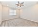 Bright, carpeted bedroom featuring a ceiling fan, neutral walls, and a large window, offering a blank canvas at 1803 Jackson St, Fortville, IN 46040