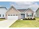 Charming brick home with a two-car garage, well-maintained lawn and nice landscaping at 1803 Jackson St, Fortville, IN 46040