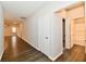 Hallway with wood floors featuring neutral paint color and doors to rooms at 1803 Jackson St, Fortville, IN 46040